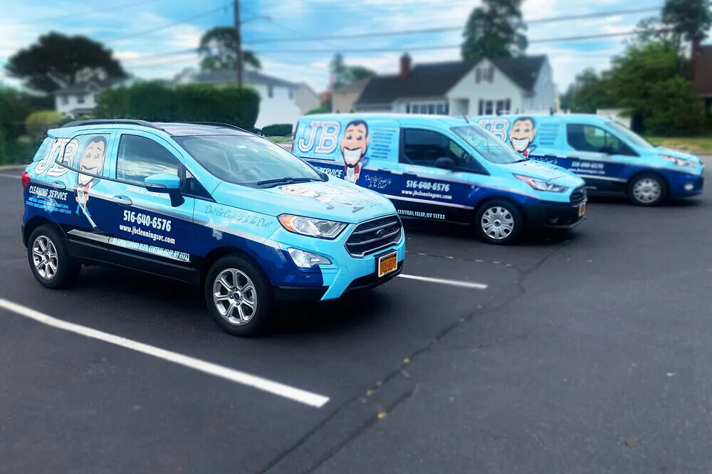 Fleet of blue and white wrapped commercial vehicles parked in a lot