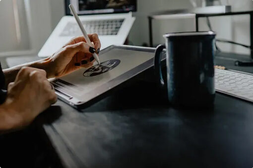 Designer sketching a logo on a drawing tablet