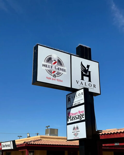 Pole sign with lighted cabinets for Next Level barbershop, Valor Health and Wellness and Desert Rose Massage